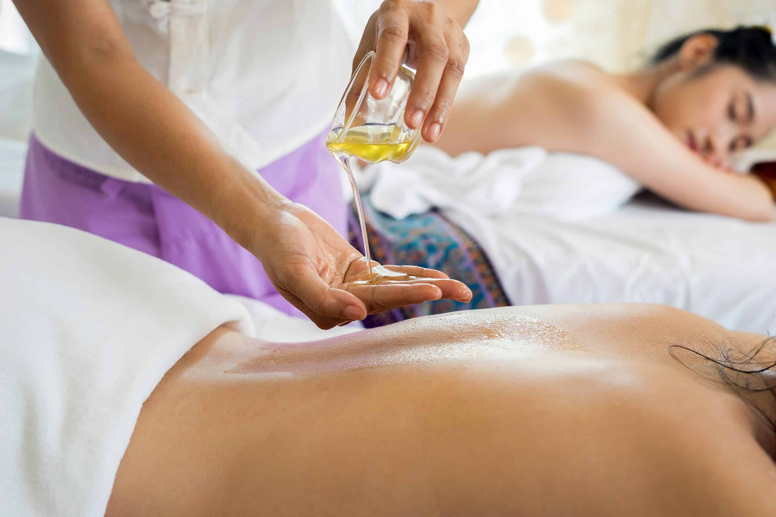 woman pouring oil on hand in preparation for massage.
