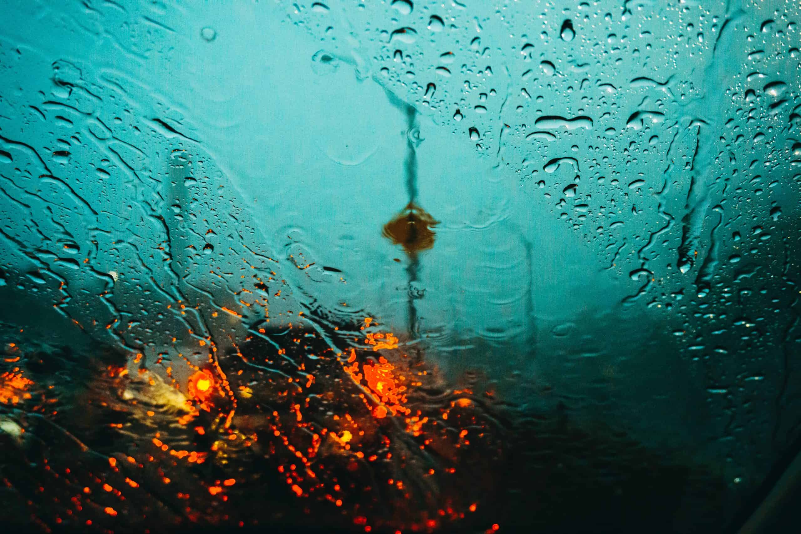 View of the road through a wet windshield.