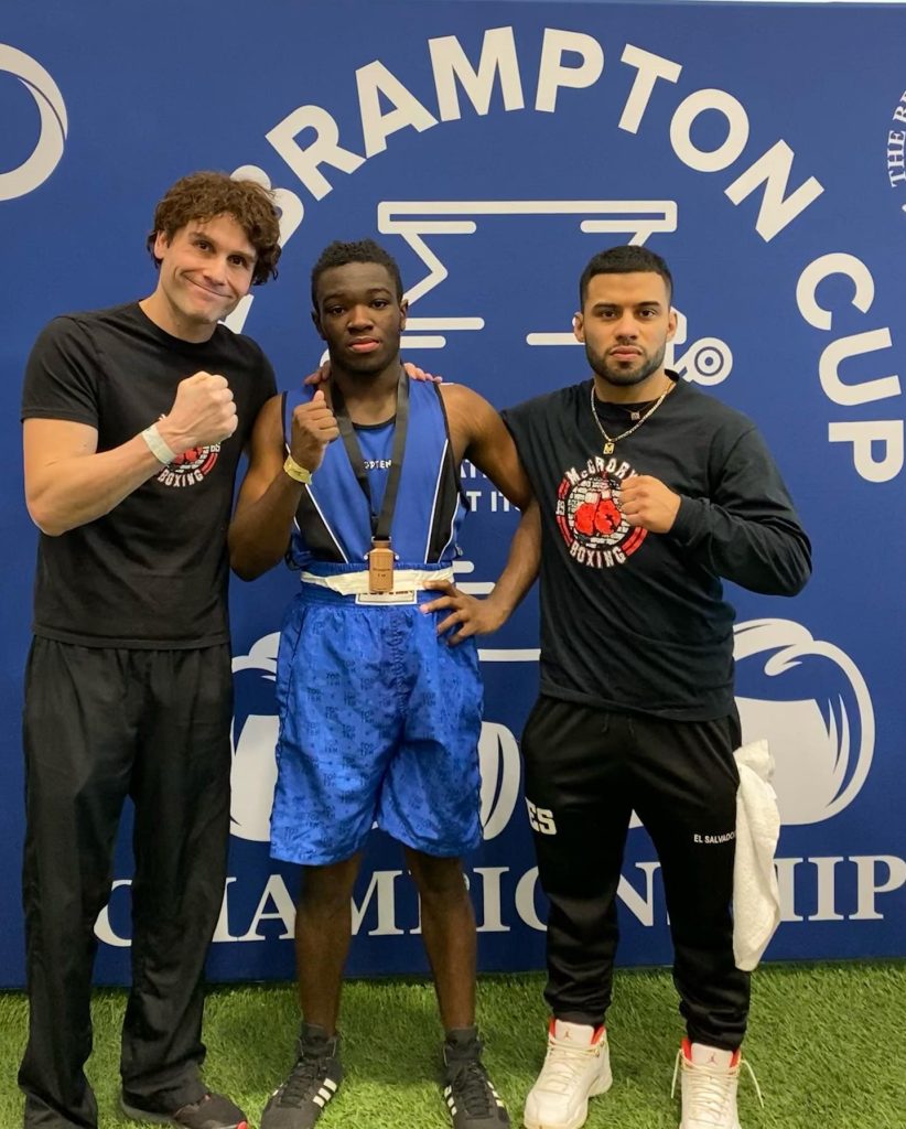 Dejaun Lawrence, 17, centre, celebrates his win at the Brampton Cup with McGrory's coaches Lawrence Hay, left, and Rodolfo Velasquez, right.COURTESY OF MCGRORY'S BOXING CLUB